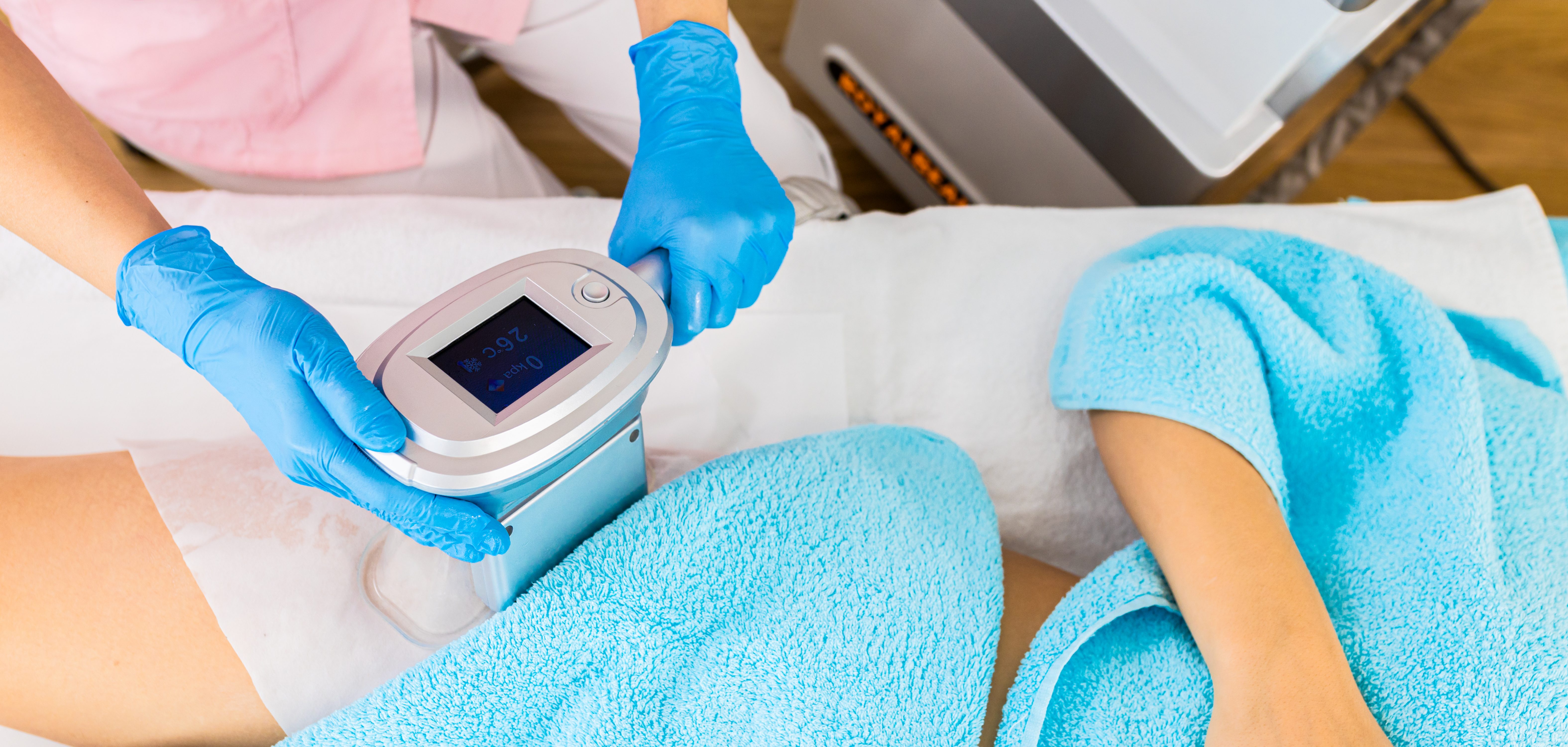Close up of beautician therapist hands applying cryolipolysis treatment in beauty salon.